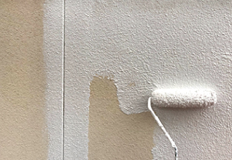 外壁に下塗りをする様子